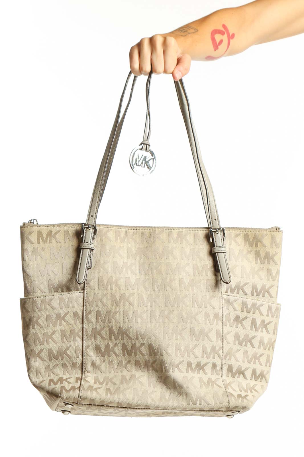 Front view of Michael Kors beige monogram tote bag with MK charm