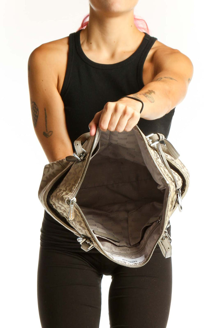 Side view of Michael Kors beige monogram tote bag worn by model