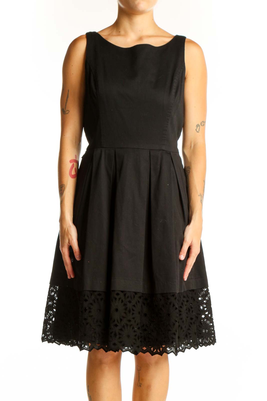 Front view of black sleeveless dress with pleated skirt and lace hem