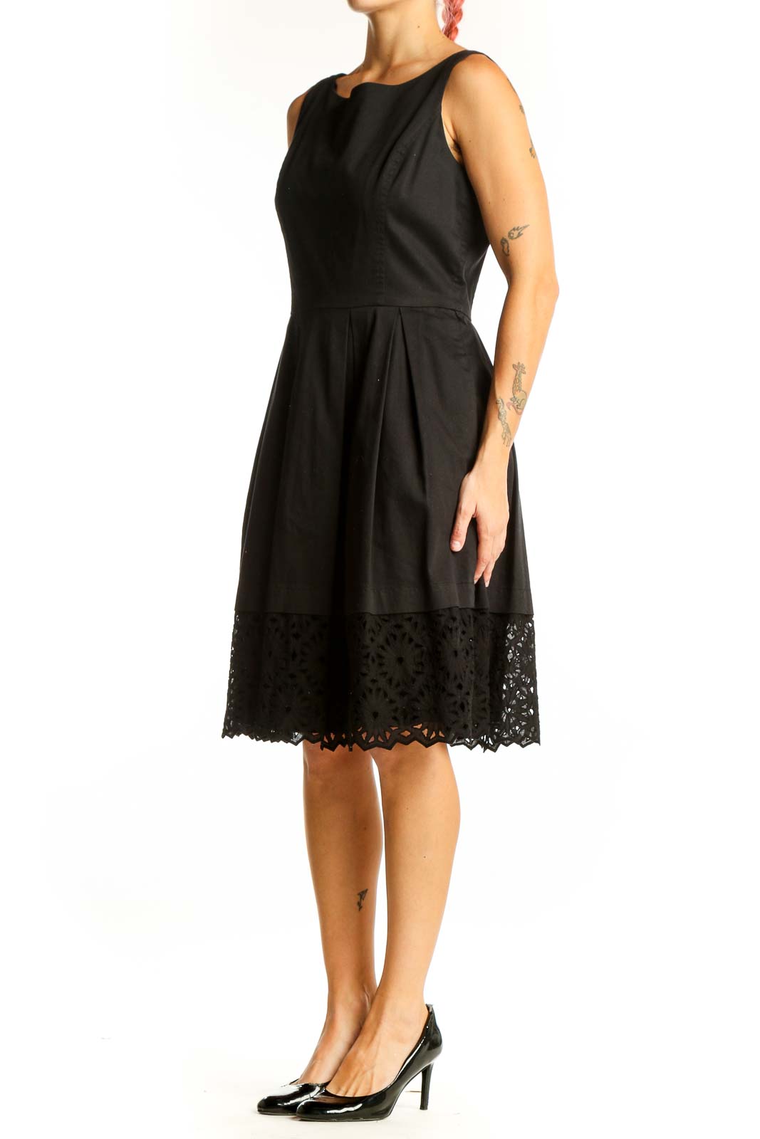 Front view of black sleeveless dress with pleated skirt and lace hem