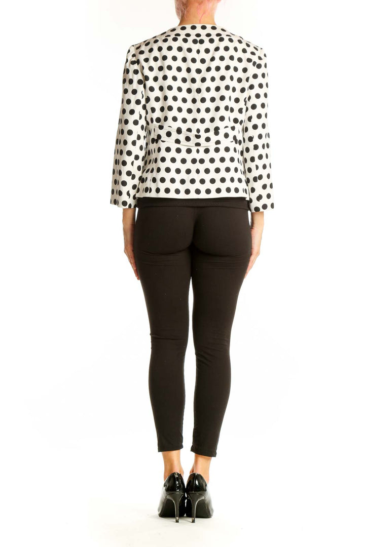 Side view of woman wearing white Talbots polka dot jacket with black pants