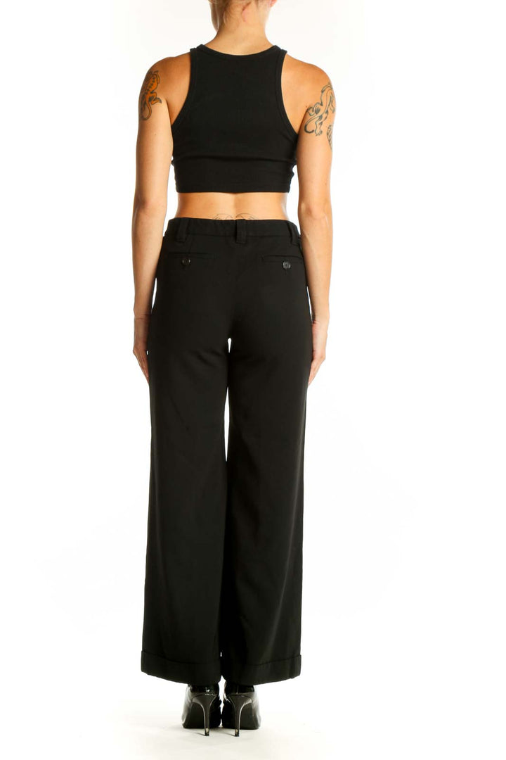 Side view of Moschino black wide-leg trousers on model