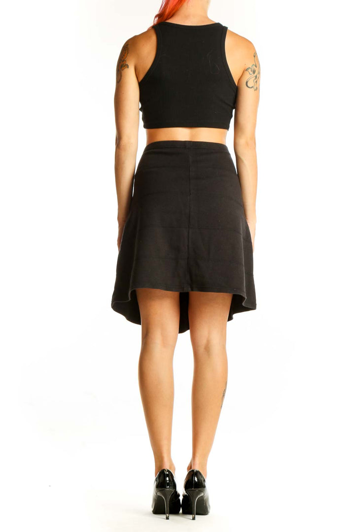 Side view of black Athleta A-line skirt on model with crop top