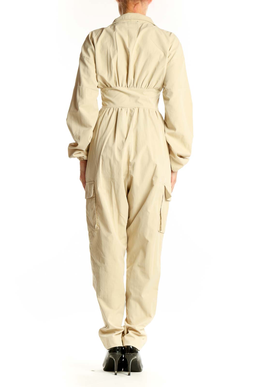 Back view of beige utility jumpsuit showing full-length design and cargo pockets