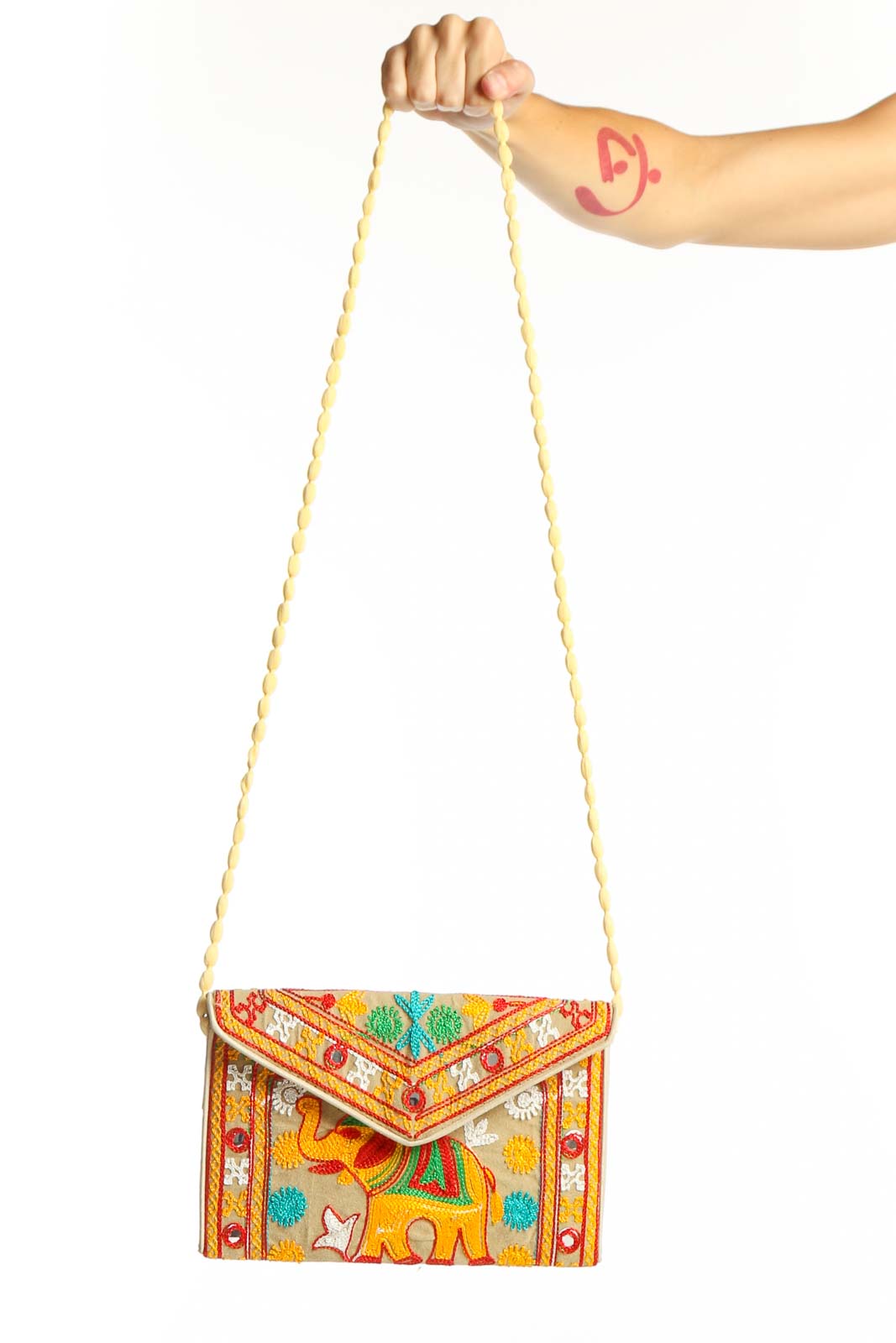 Front view of yellow embroidered elephant clutch with colorful patterns