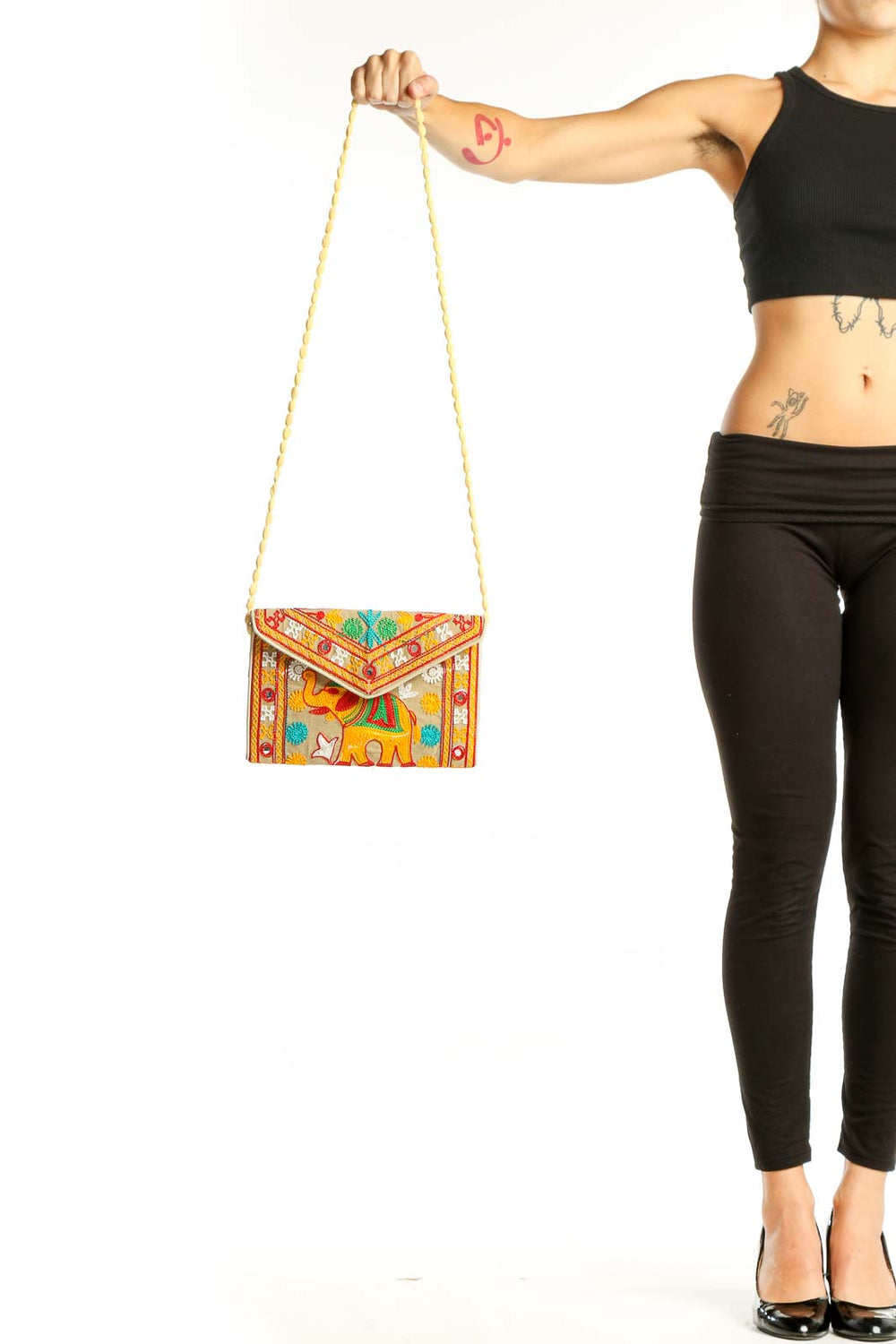 Front view of yellow embroidered elephant clutch with colorful patterns