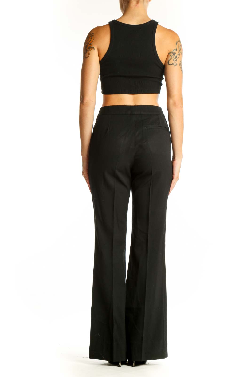 Side view of woman wearing Burberry black wide-leg trousers with crop top