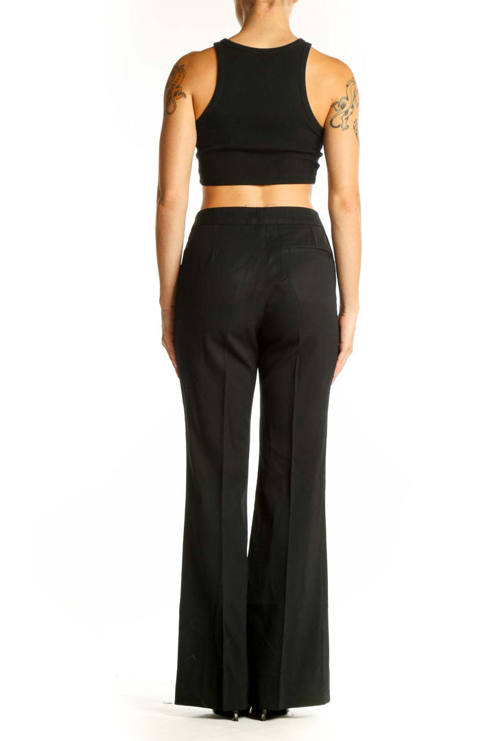 Side view of woman wearing Burberry black wide-leg trousers with crop top