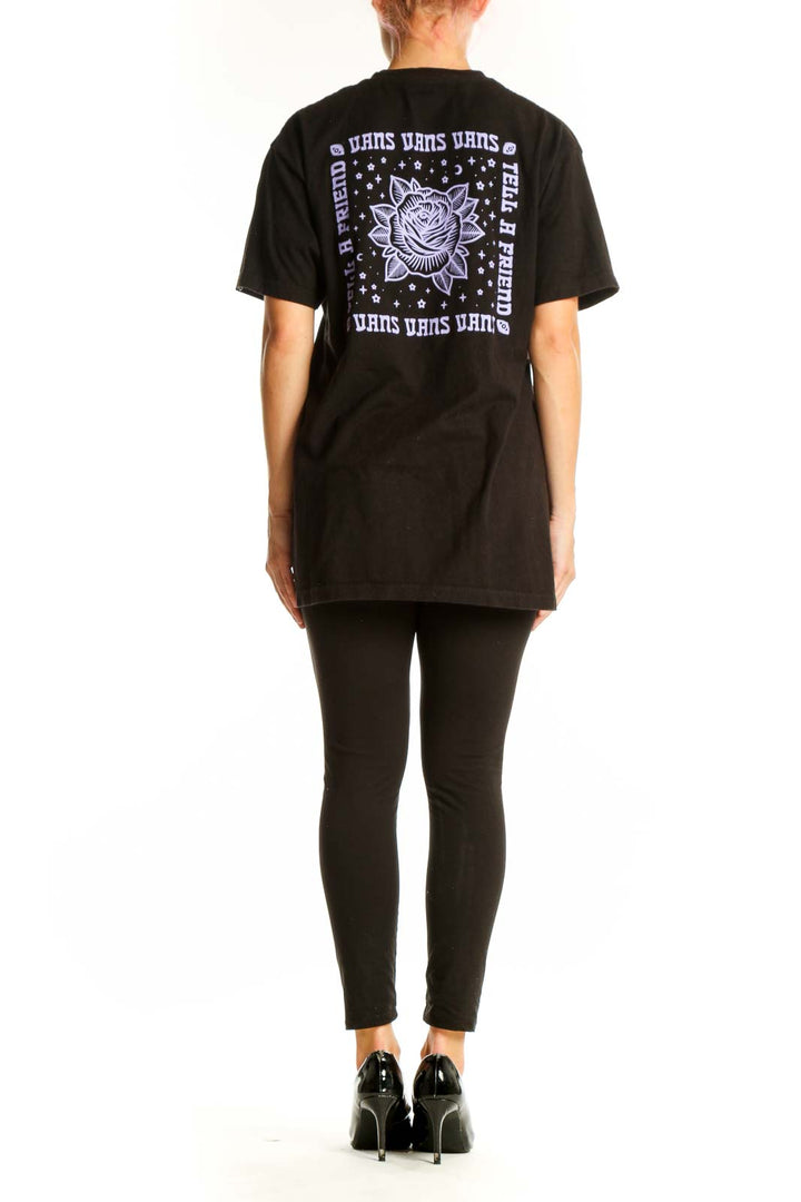Side view of person wearing black Vans t-shirt