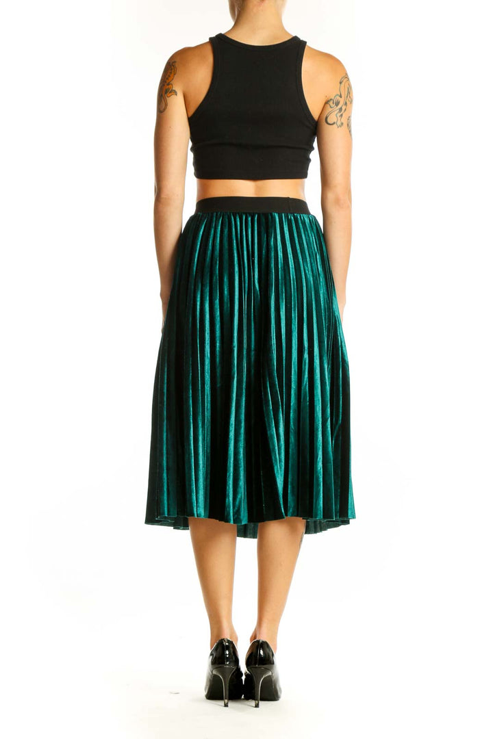 Side view of emerald green pleated velvet midi skirt with black crop top