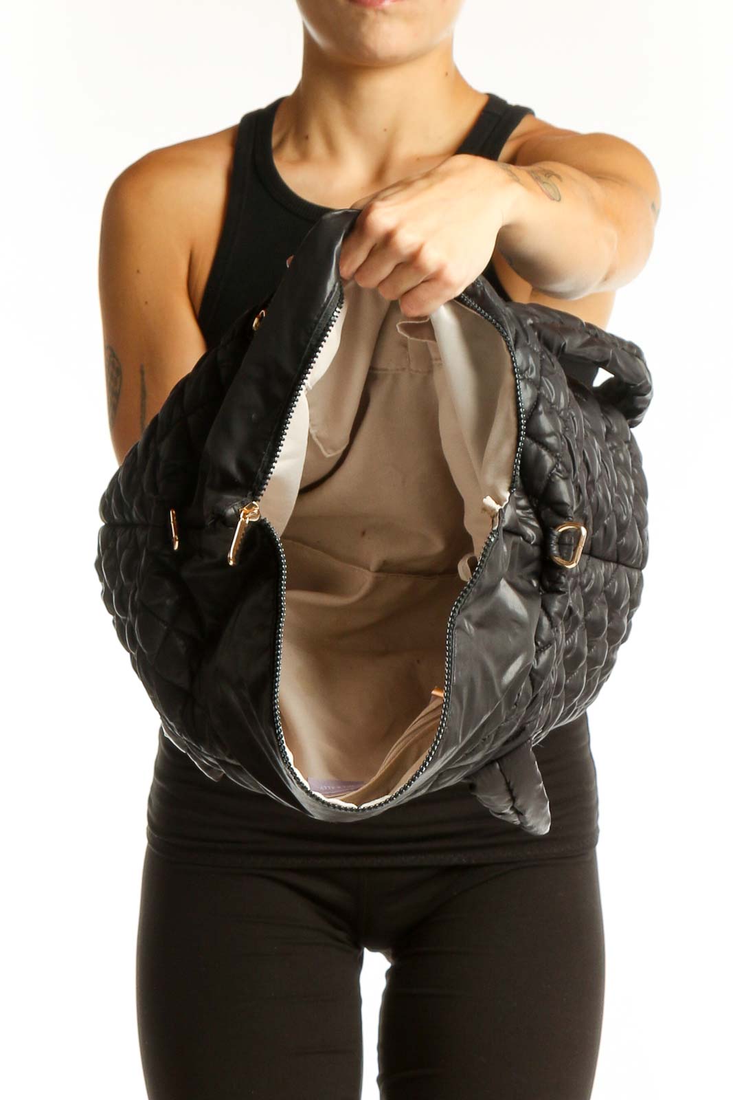 Side view of Jill & Ally black quilted tote bag worn on shoulder