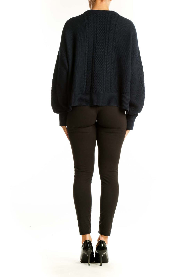 Side view of ATM black cable knit cropped sweater showing relaxed fit and length
