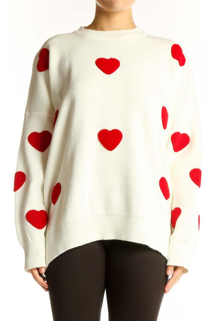 Front view of white oversized sweater with red heart pattern