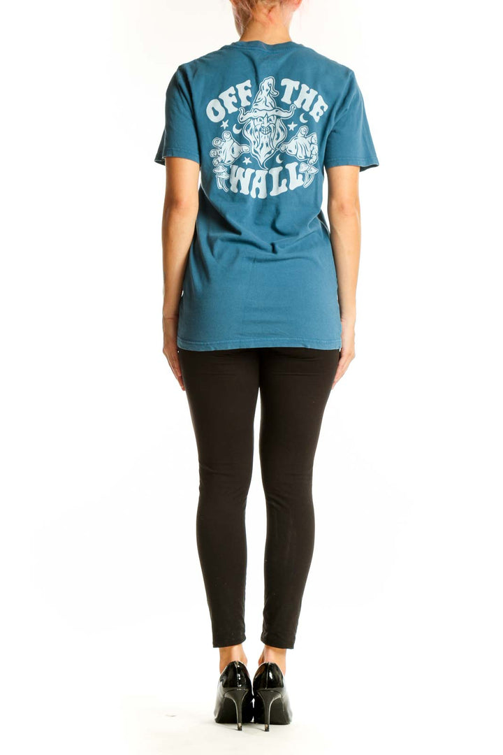 Side view of woman wearing teal Vans graphic t-shirt with black pants