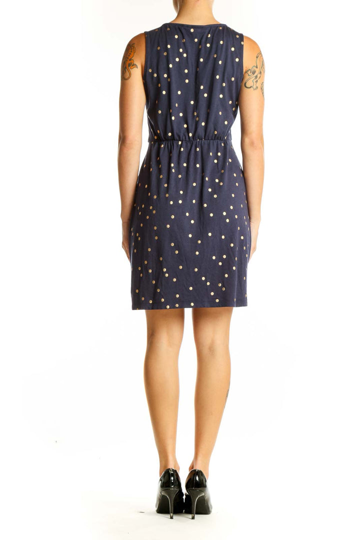 Side view of Boden navy sleeveless dress with gold polka dots
