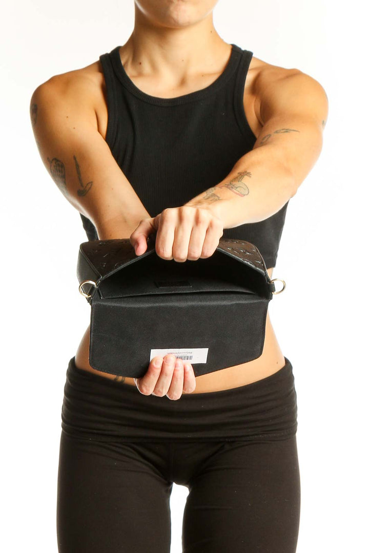Side view of Louis Vuitton black crossbody bag worn by model