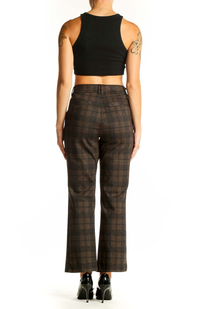 Side view of model wearing Democracy brown plaid trousers with black top