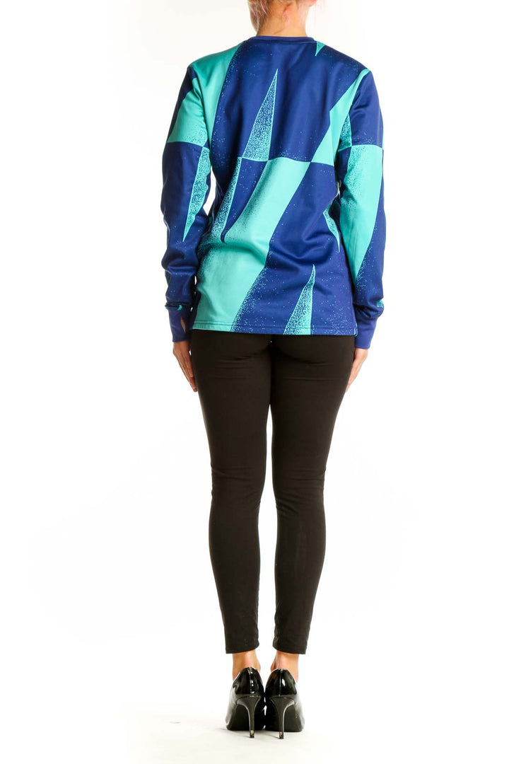 Side view of Nike FC Barcelona blue and teal geometric long sleeve athletic top on model