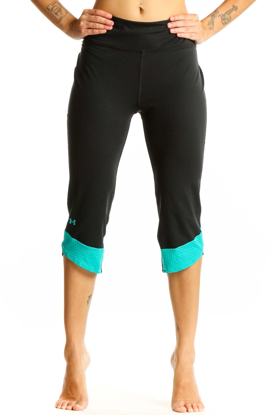 Front view of black Under Armour capri leggings with teal cuffs