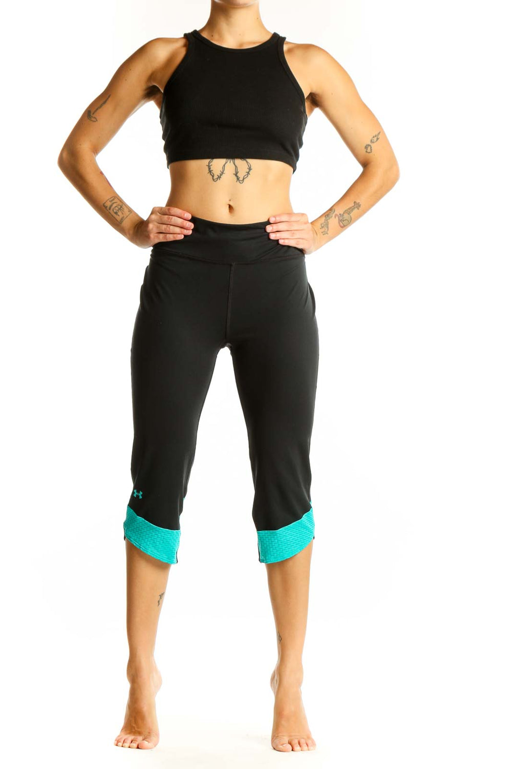 Front view of black Under Armour capri leggings with teal cuffs