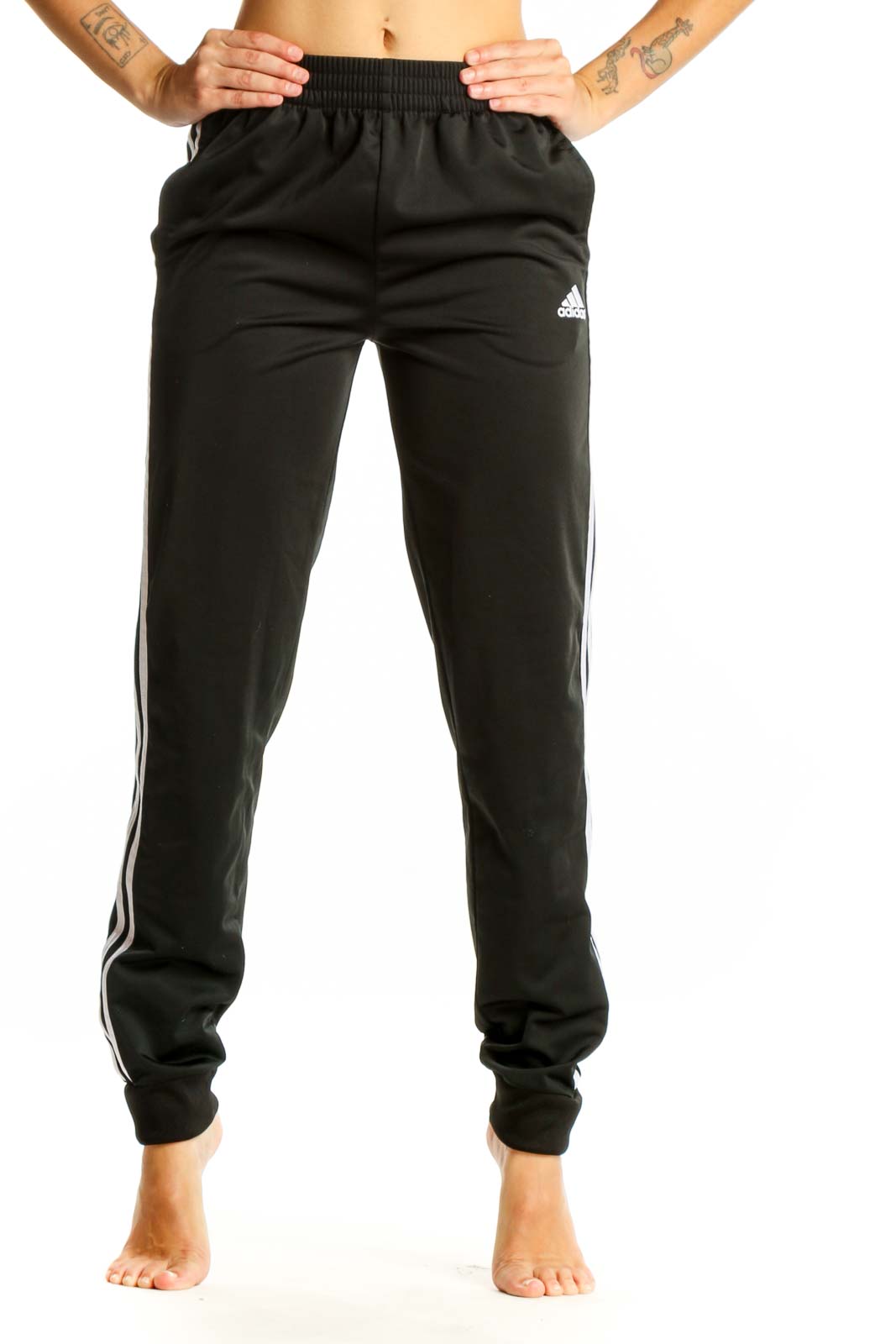 Front view of black Adidas track pants with white stripes