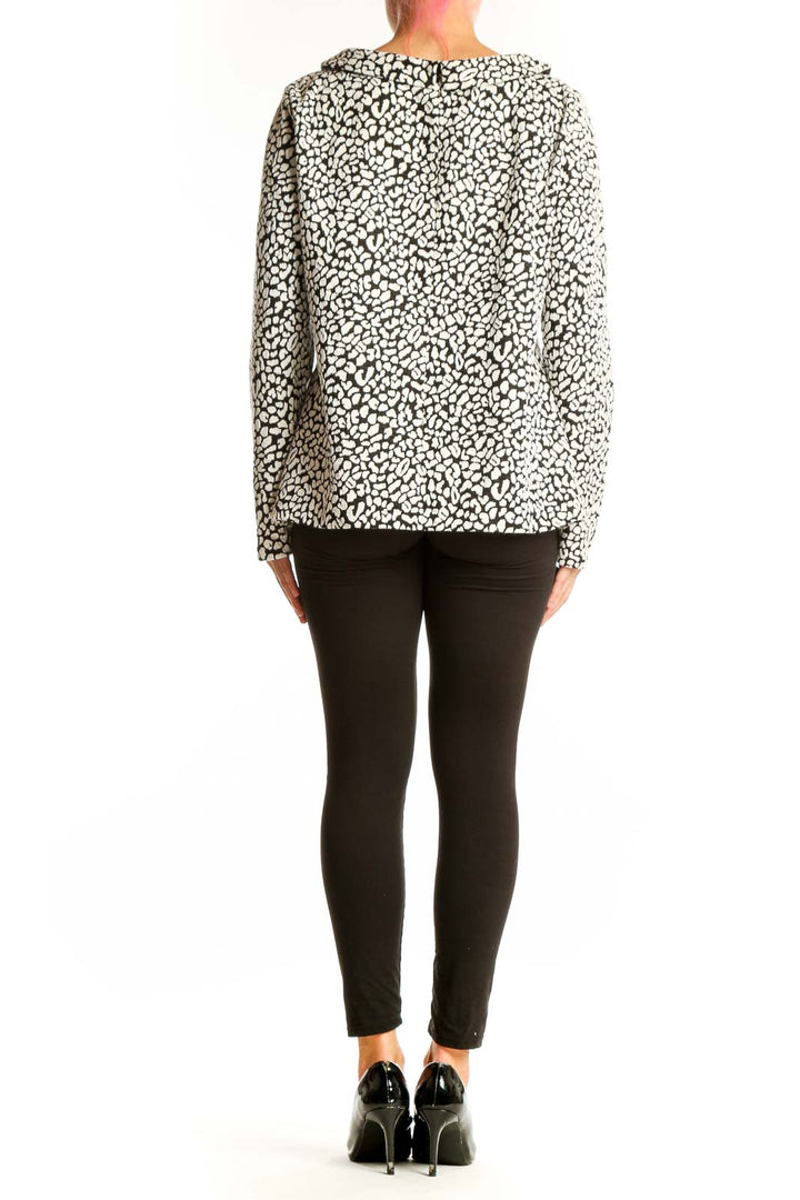 Side view of model wearing Talbots black and white leopard print long sleeve top with black pants
