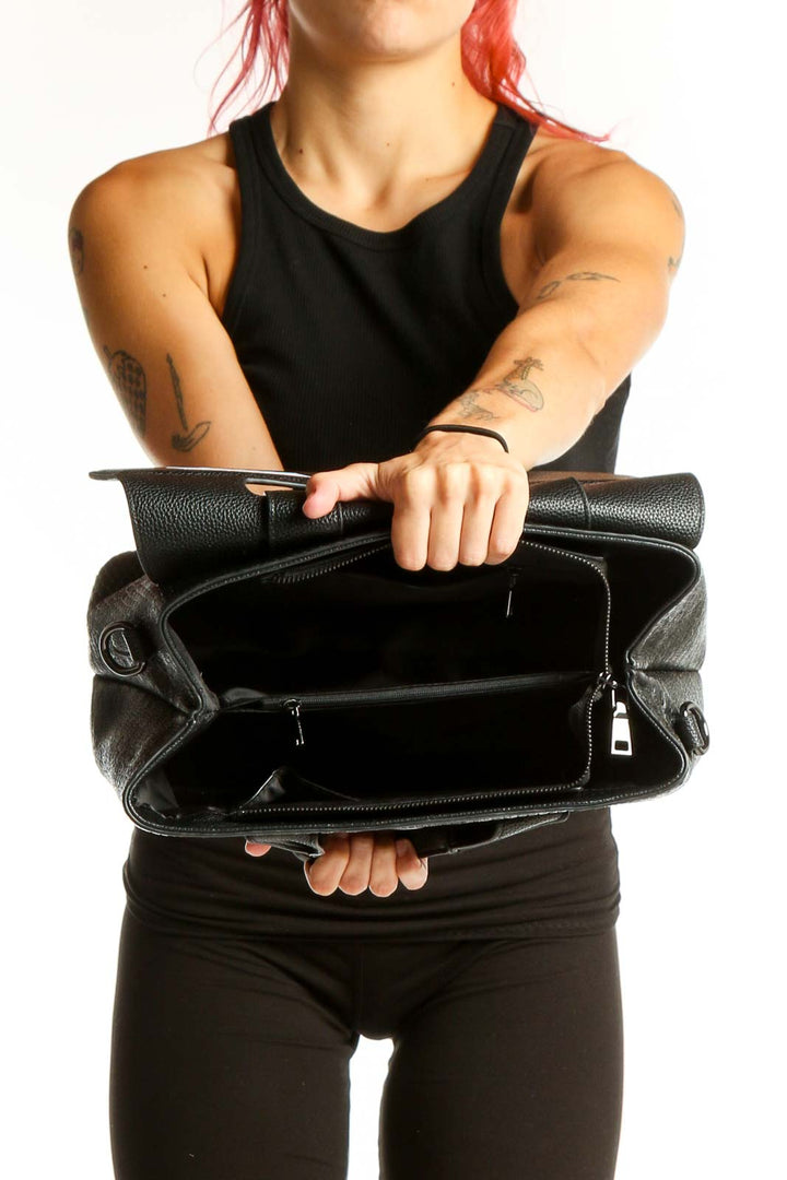 Side view of SilkRoll black leather satchel worn by model
