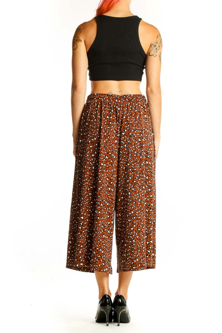 Side view of model wearing Banana Republic brown leopard print wide-leg cropped pants with black top