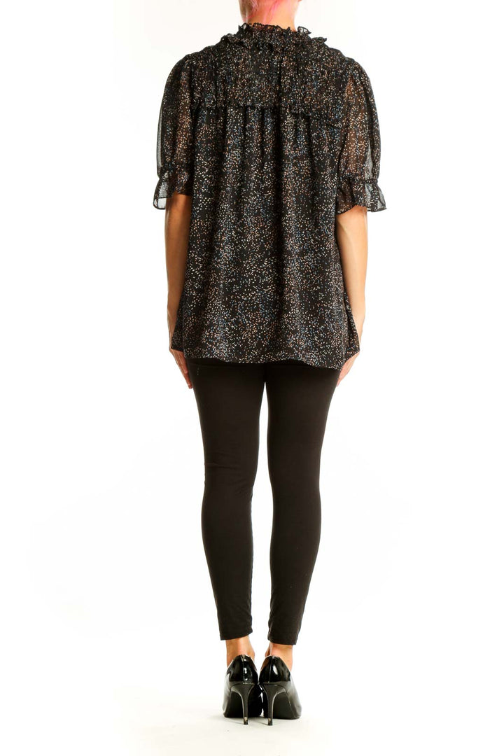 Side view of Pleione black speckled sheer blouse on model