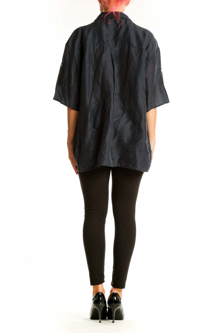 Side view of model wearing black oversized Mango button-down shirt with black pants