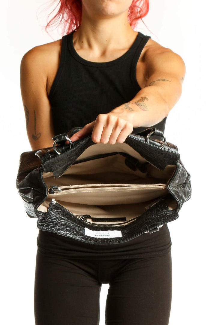 Model holding black croc-embossed leather shoulder bag from Talbots