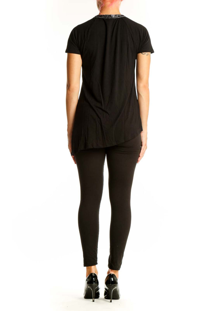 Side view of Design History black asymmetrical top showing drape and fit