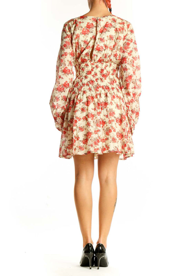 Side view of cream Free People mini dress showing flowy skirt and bishop sleeves