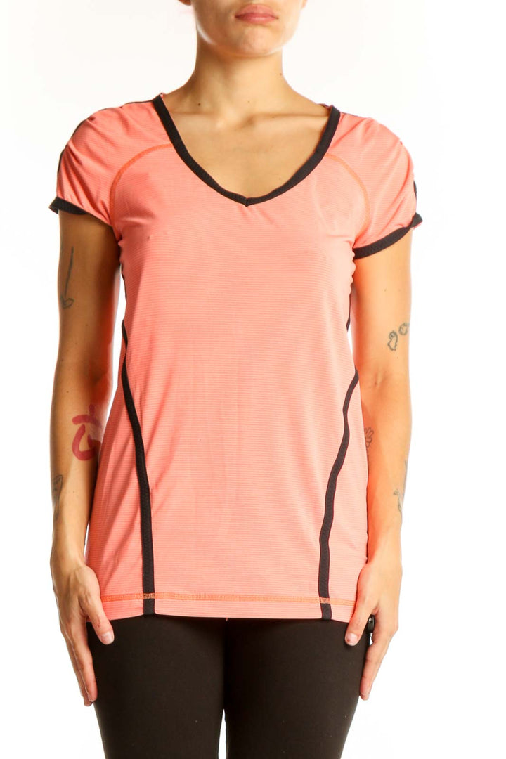 Front view of coral Lululemon V-neck performance top with black trim