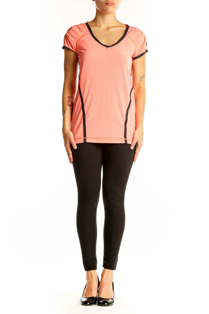 Front view of coral Lululemon V-neck performance top with black trim