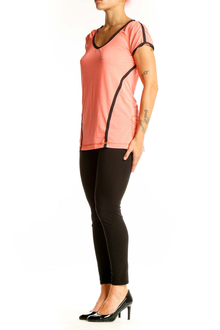 Front view of coral Lululemon V-neck performance top with black trim