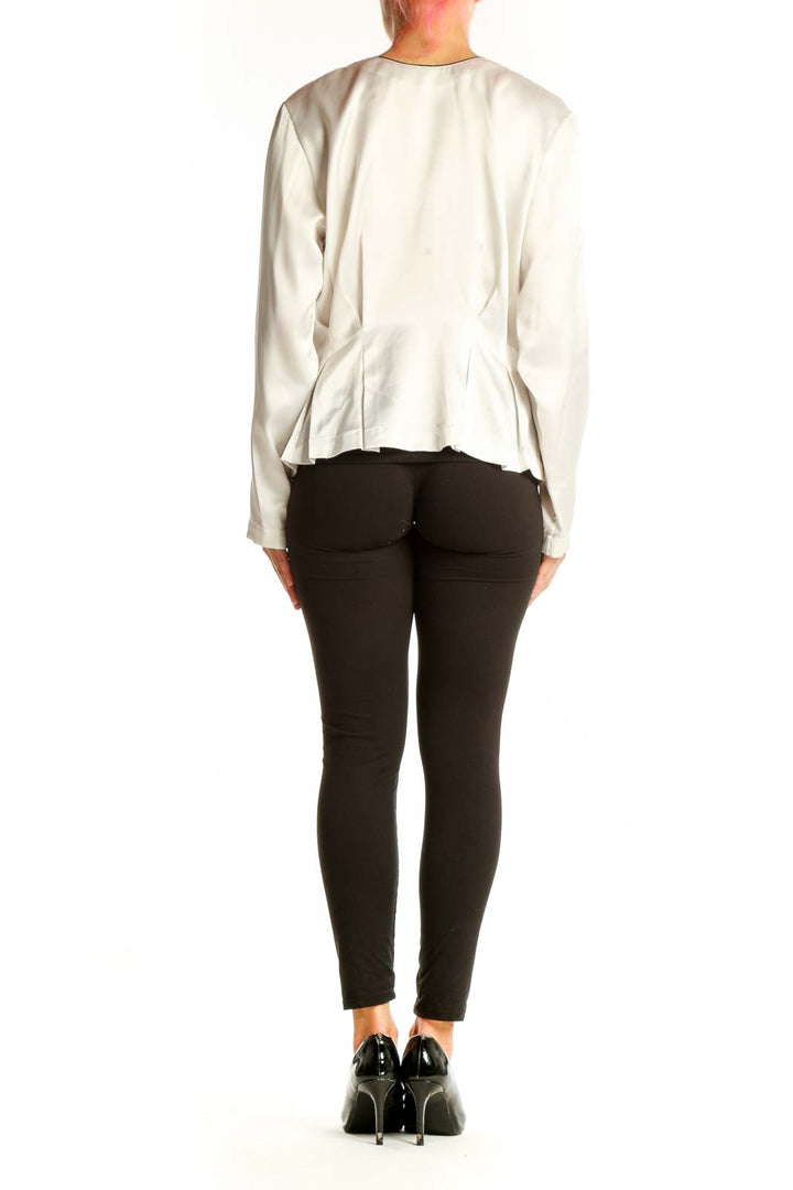 Side view of white Josephine polyester blouse showing peplum waist and long sleeves