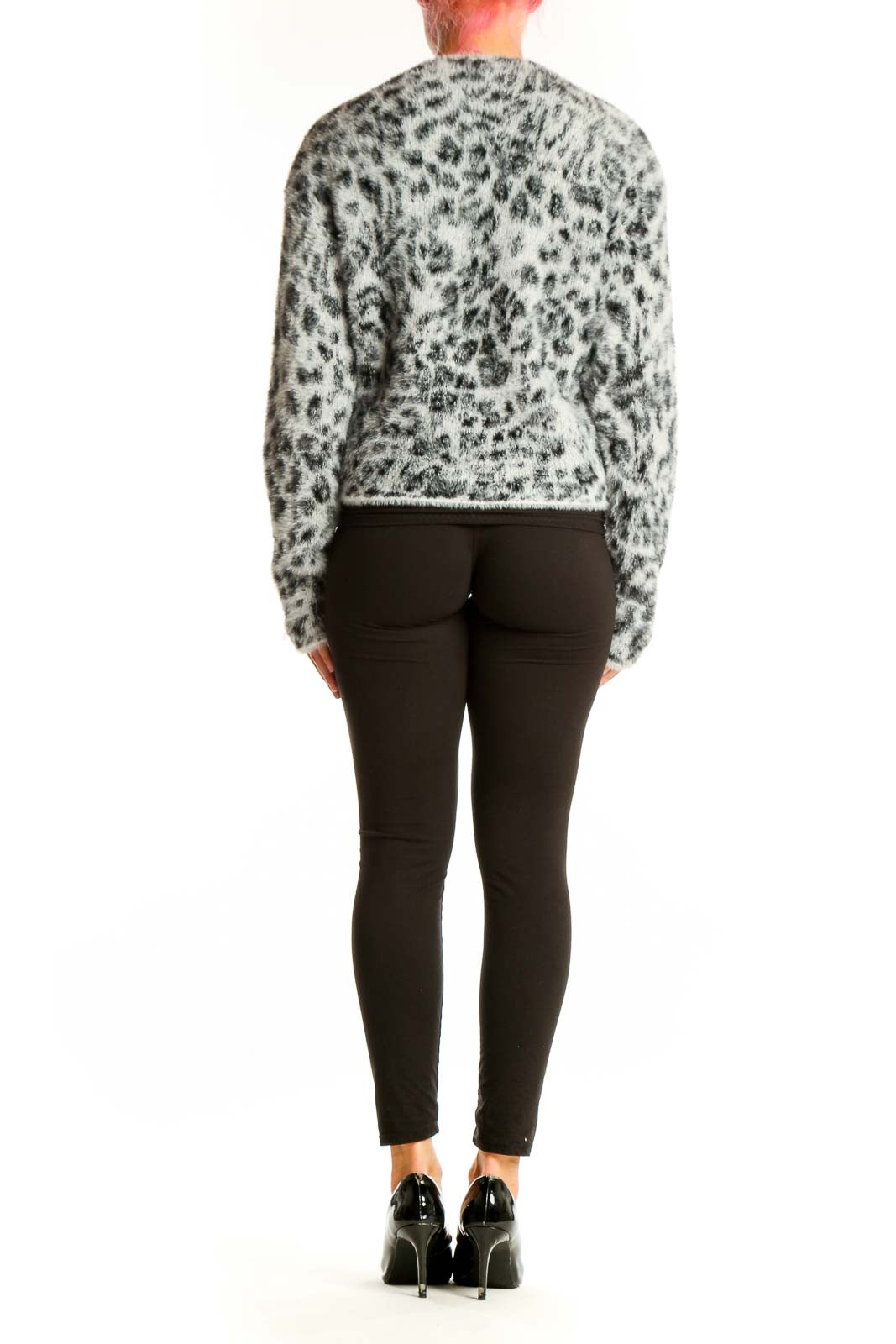 Side view of model wearing gray leopard print fuzzy knit sweater with black pants