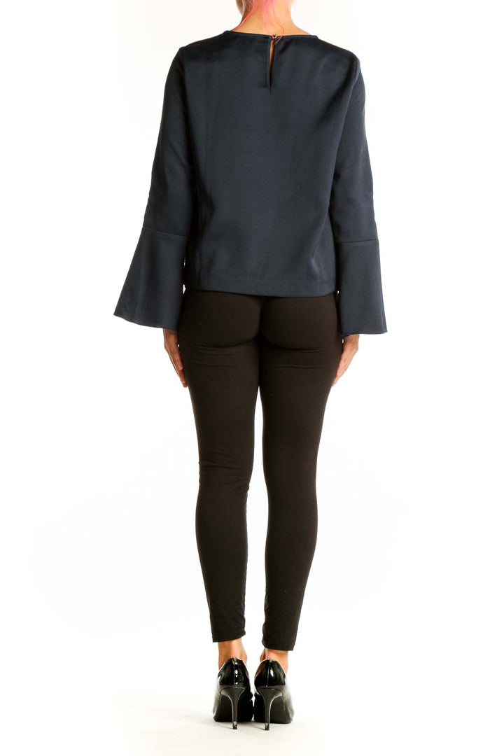 Side view of Vince Camuto navy blouse showing bell sleeve detail