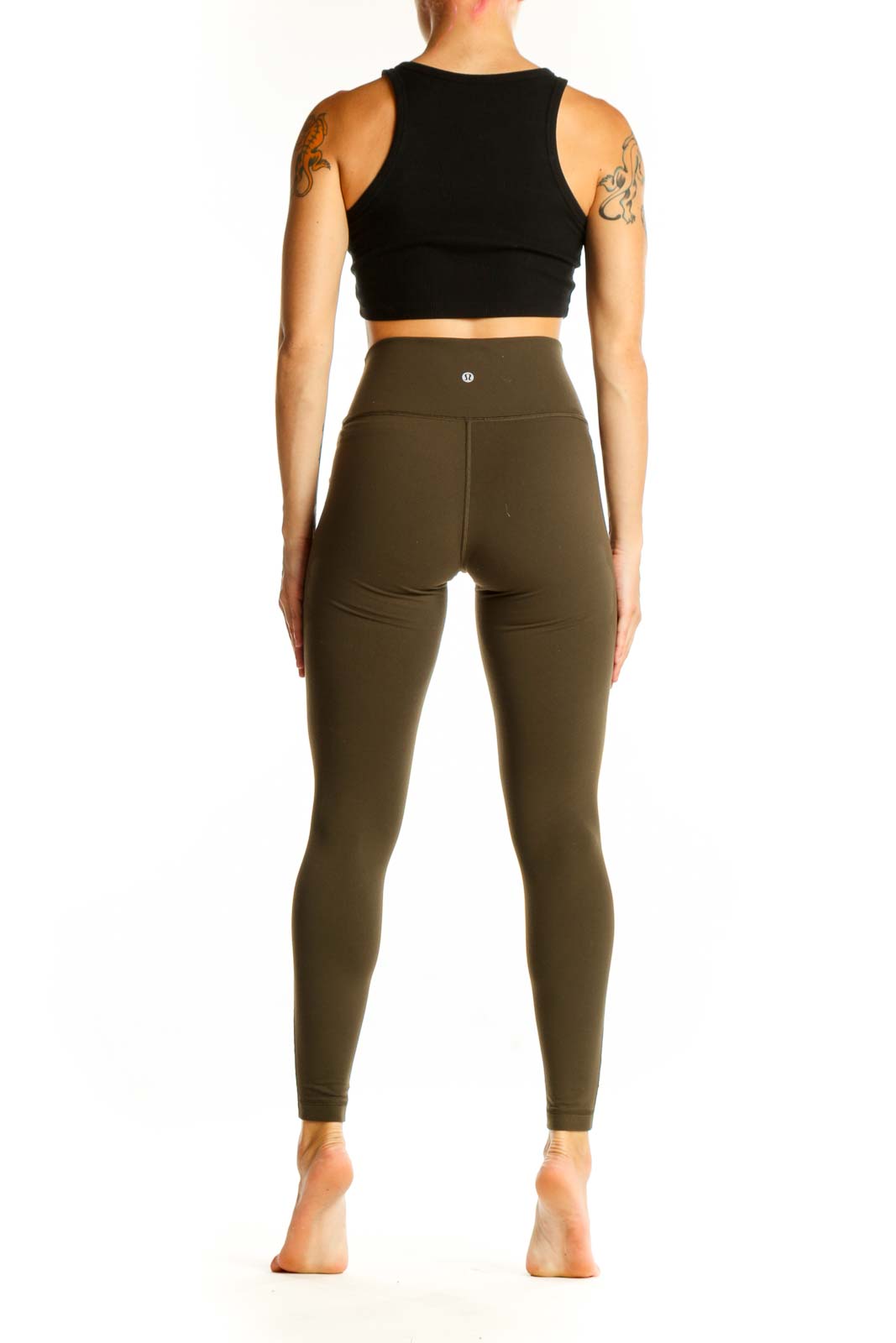 Side view of woman wearing Lululemon olive mesh panel leggings with black crop top