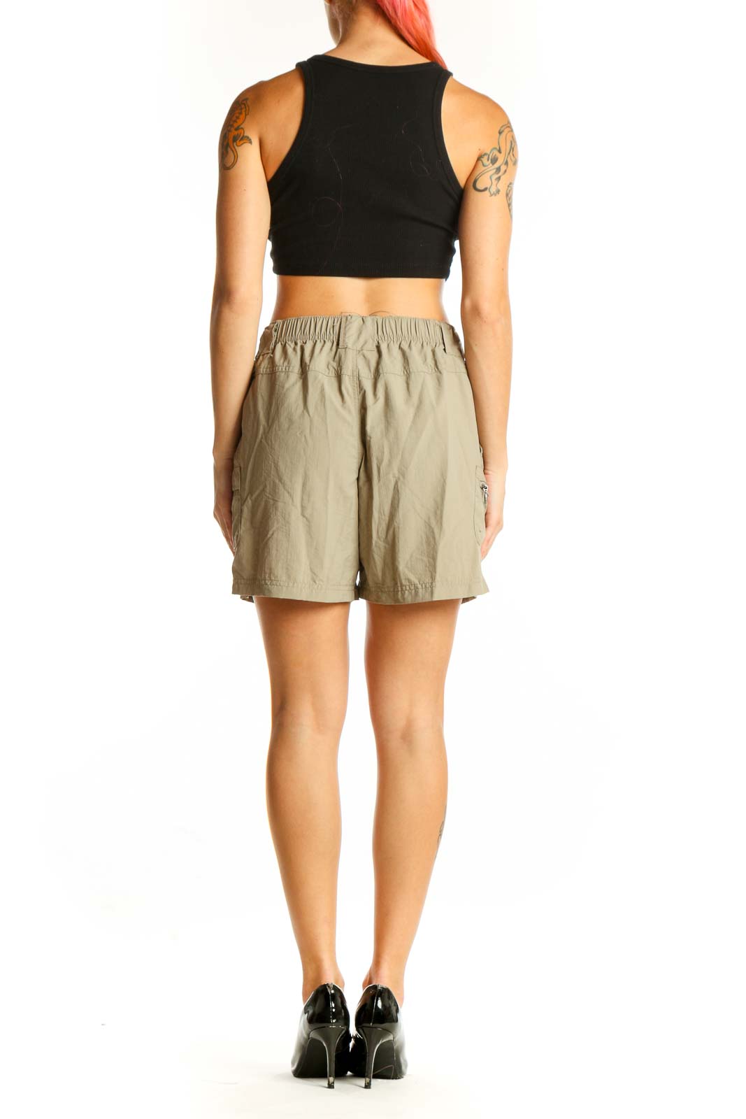 Back view of khaki Columbia nylon shorts on model with black top