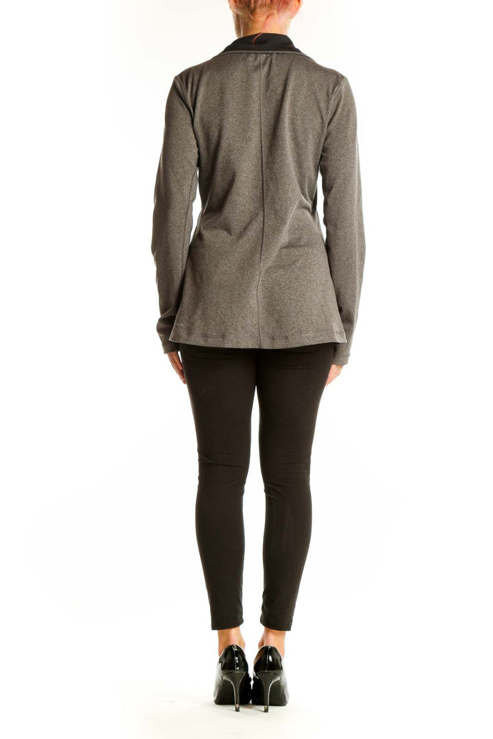 Side view of woman wearing gray Reebok athletic jacket