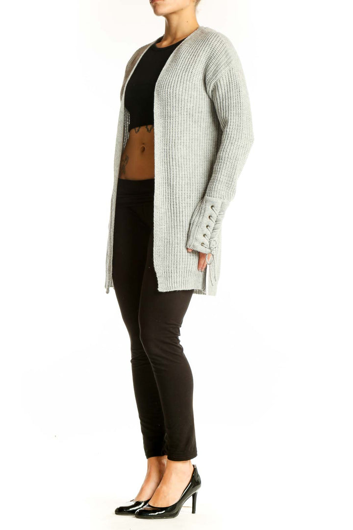 Front view of gray chunky knit cardigan with lace-up sleeve details
