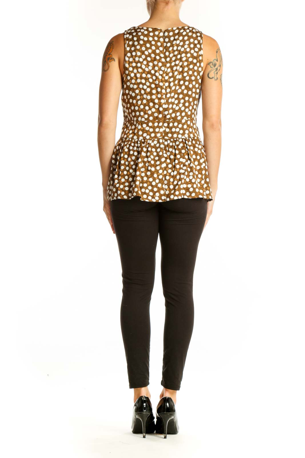 Side view of model wearing J.Crew brown polka dot peplum top with black pants