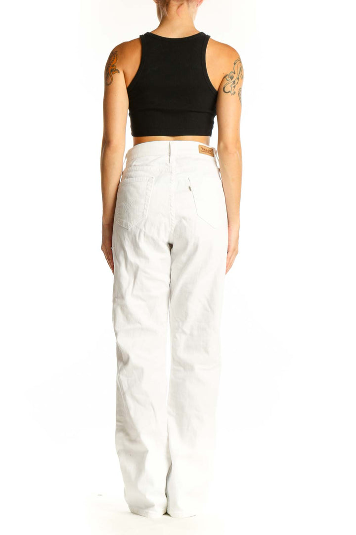 Side view of Levi's white straight leg jeans on model with black crop top