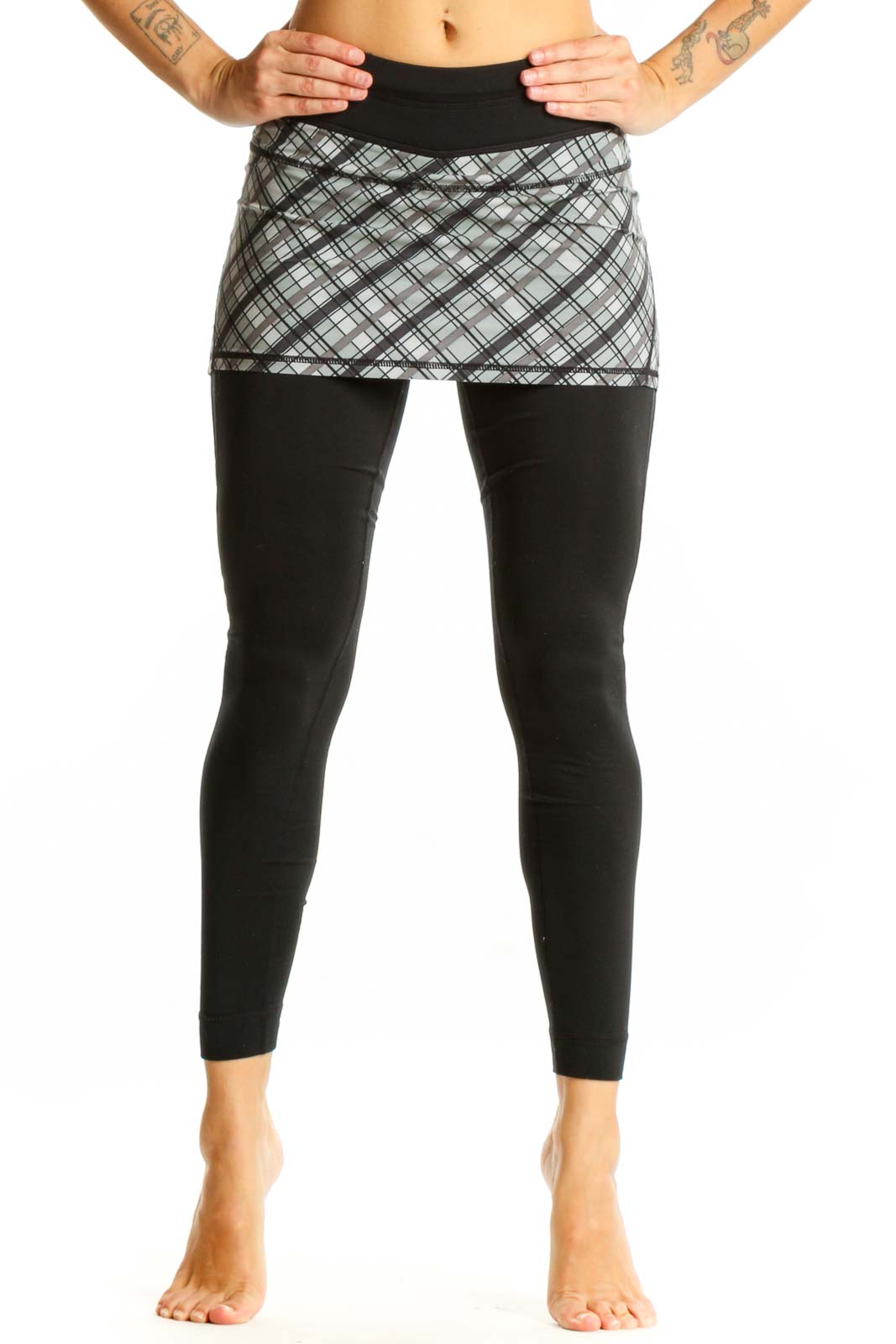 Front view of Athleta black leggings with gray plaid skirt overlay