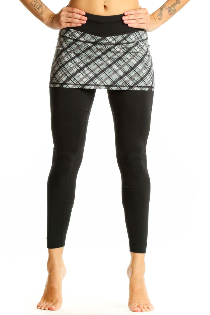 Front view of Athleta black leggings with gray plaid skirt overlay