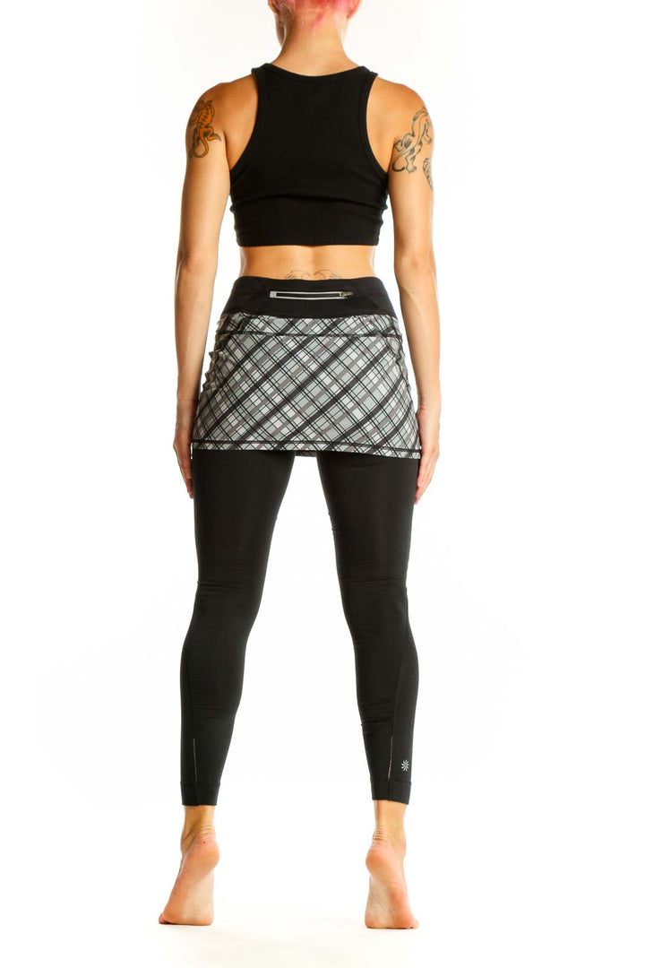 Side view of woman wearing Athleta black skirted leggings with gray plaid pattern