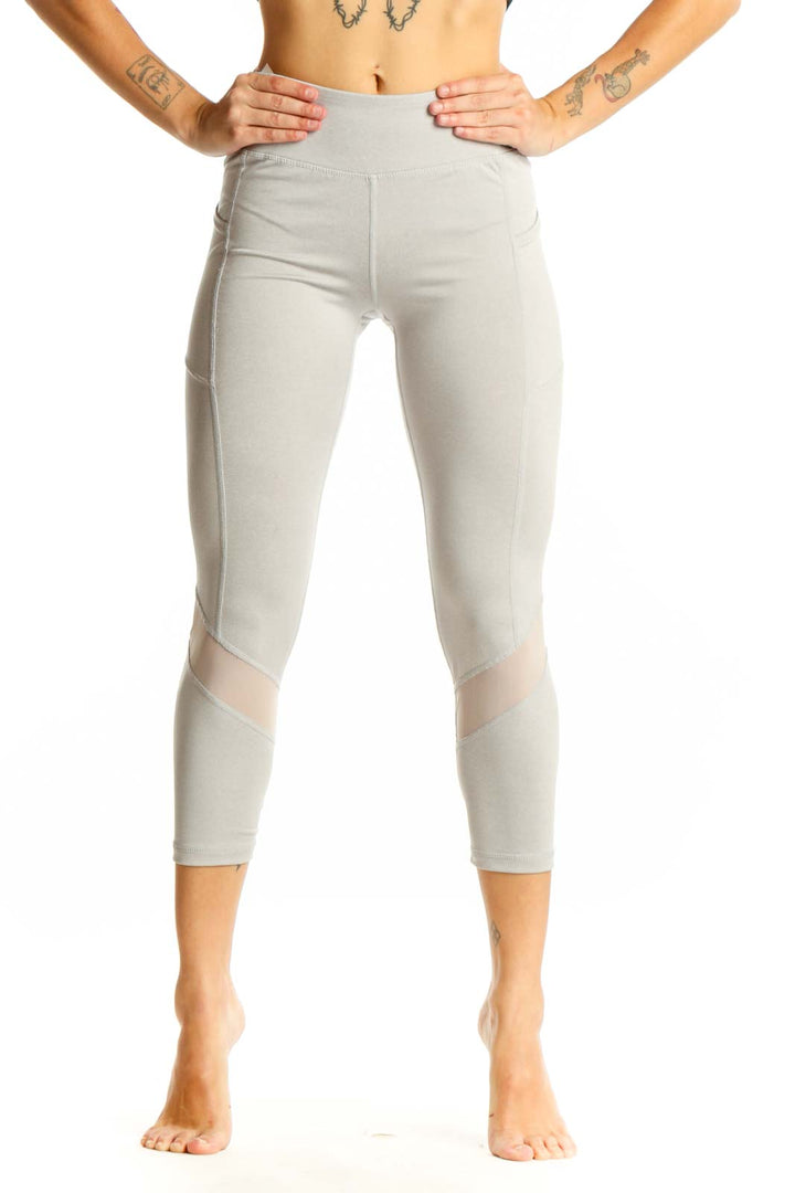 Front view of light gray Reebok capri leggings with mesh panels