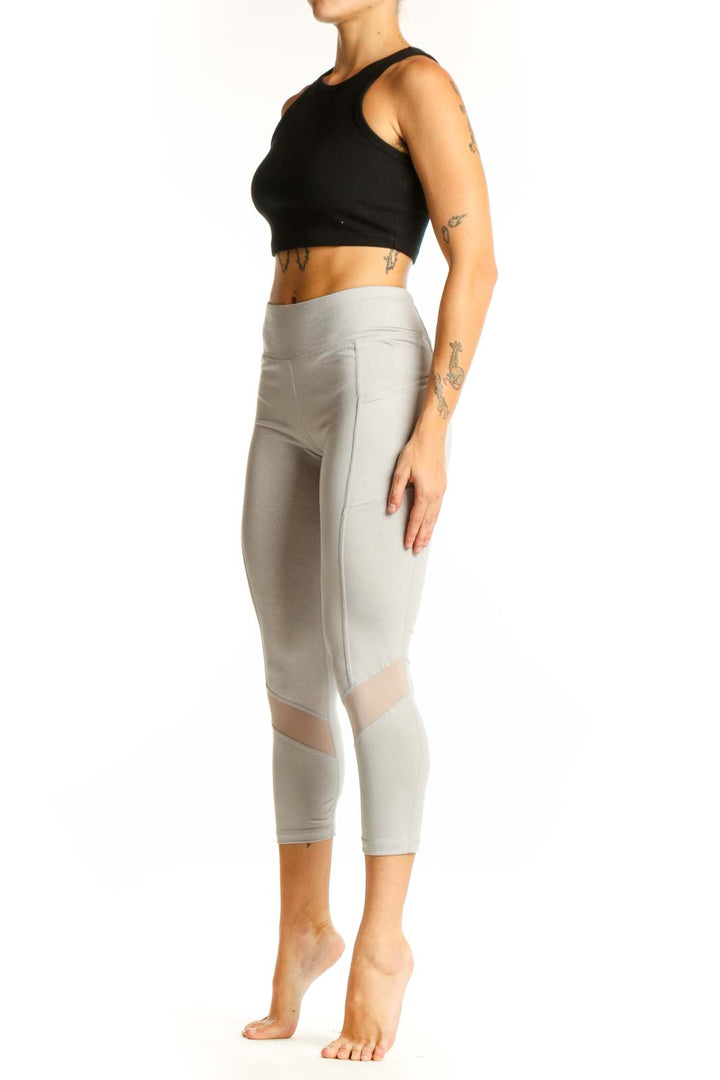 Front view of light gray Reebok capri leggings with mesh panels